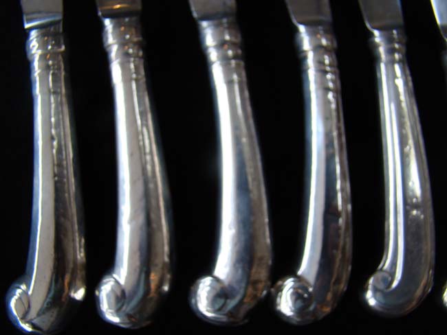 An assembled set of 5 Georgian 18th century sterling silver dinner knives with pistol form handles